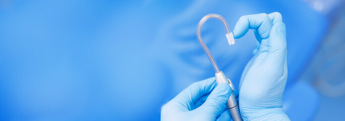 Concept banner dentist dentistry. Hand in blue latex glove with saliva ejector symbolize love heart...
