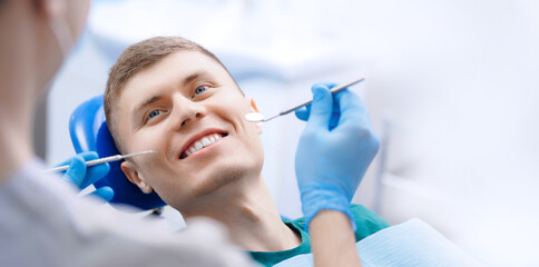 Dentist examining man patient teeth in dentist clinic, white background banner with copy space
