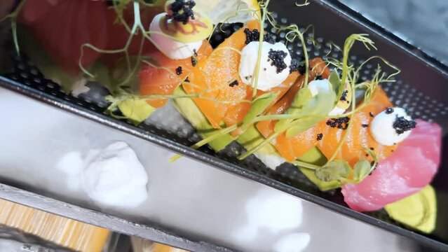 Sushi with salmon, cheese, herbs and smoke.
