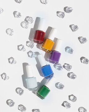 Set of colorful nail polish on white background with gems