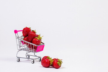 Strawberries in shopping cart on white background