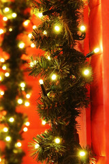 Christmas background made of fir branches, balls and lights in low key - 698704883