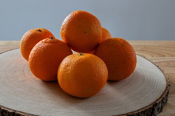 oranges citrus displayed on a wooden log chopping board