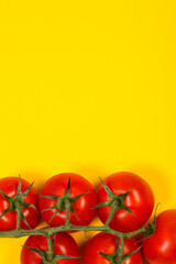 Red cherry tomatoes on a yellow background