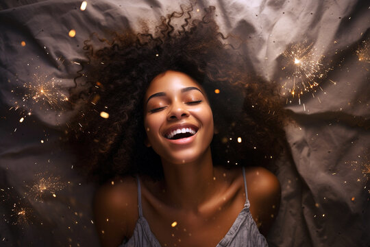 Young african american woman having orgasm. Beautiful woman with closed eyes enjoying sex lying among fireworks. Sparklers as a symbol of orgasm. Sexual experience, masturbation, cunnilingus.