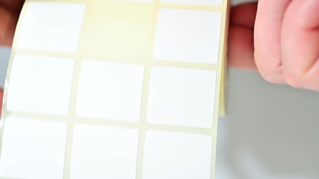 Opening barcode roll labels by hand. Opened thermal barcode roll.	