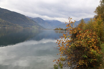 Lake Zell with Kitzsteinhorn and autumn foliage on trees, selective focus 