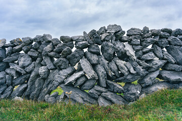 Beautiful rural dry stone wall in County Clare Burren contrasted with grass and cloudy sky