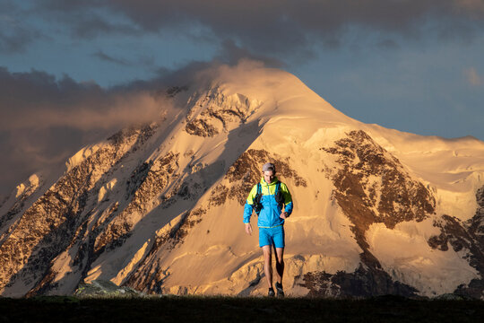 Adventurer hiking in mountain terrain at sunset