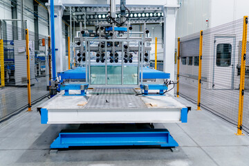 Conveyor production of large sheets of cut glass. Modern automated machines in factory. Interior of a large glass and mirror cutting factory.