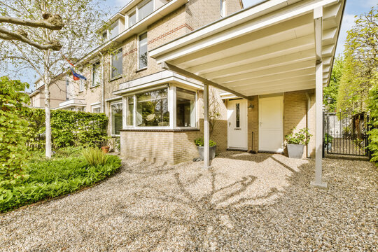 Front of brick house with gravel driveway