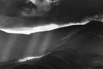 Amazing landscape of mountains hills in sunbeam and cloudy sky in black and white shadow light. Monochrome style. - 698743635