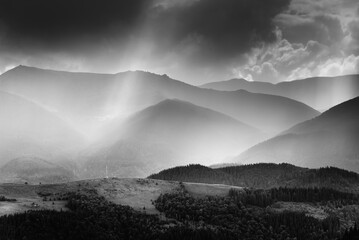Amazing landscape of mountains hills in sunbeam and cloudy sky in black and white shadow light. Monochrome style. - 698743655