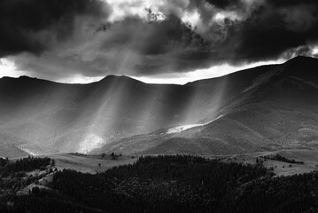 Amazing landscape of mountains hills in sunbeam and cloudy sky in black and white shadow light. Monochrome style. - 698743663