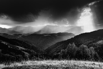 Amazing landscape of mountains hills in sunbeam and cloudy sky in black and white shadow light. Monochrome style. - 698743675