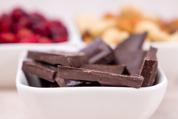 Chocolate bars with nuts and berries on a white background. Selective focus.