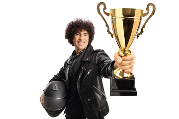 Guy in a black leather jacket holding a helmet and a gold tropy cup