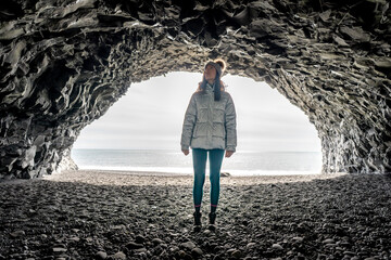 Woman alone inside Reynisfjara cave in Iceland - obrazy, fototapety, plakaty