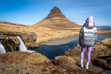 Naklejka premium Woman from behind in Kirkjufell, Iceland