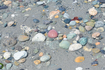 Mixture of natural stones and pebbles in shallow ocean water