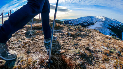 Woman with hiking backpack walking on snow covered alpine meadow on trail from Ladinger Spitz to...