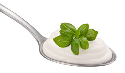 Sour cream with basil leaves in spoon isolated on white background
