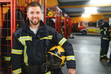 Fireman wearing protective uniform standing in fire department at fire station
