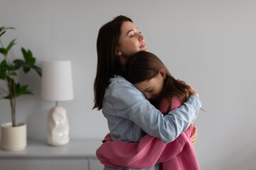 Mother hugging and comforting crying teen daughter, showing love support to sad child, embracing...