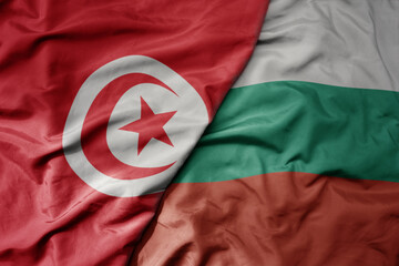 big waving national colorful flag of bulgaria and national flag of tunisia .