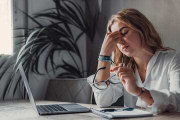 Stressed tired woman in pain having strong terrible headache attack after computer laptop study,...