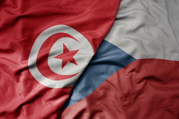 big waving national colorful flag of czech republic and national flag of tunisia .