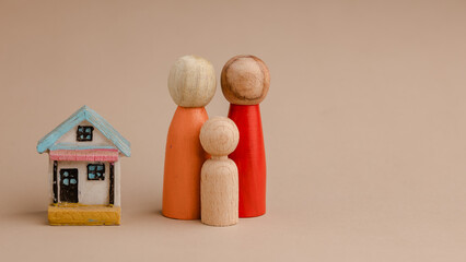 Wooden family peg doll with wood home. Concepts of love, protection, planning and saving. Happy...