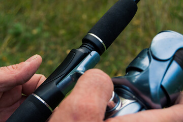 hands putting the reel on a fishing rod