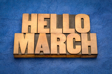 Hello March word abstract in vintage letterpress wood type against textured handmade paper, cheerful greetings