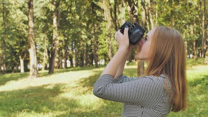 A girl taking pictures with her camera on a summer day.