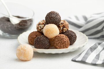 Typical Brazilian sweet brigadeiro. A heap of assorted flavors of candies on a white table
