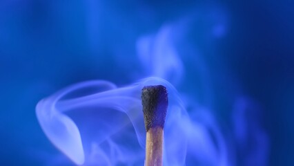 Macro shot of a black charred match and clouds of white smoke. Burned extinguished wooden match on...