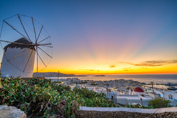 Windmill at beautiful sunset over horizon in Mykonos, Greece