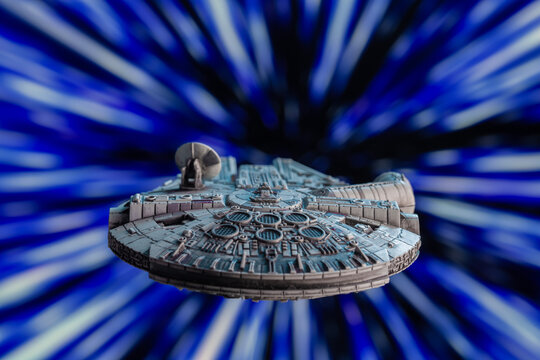 NEW YORK, USA: DEC 29 2023 - Star Wars Corillian freighter Millennium Falcon traveling through hyperspace - Kessel Run - X-Wing miniature game ship