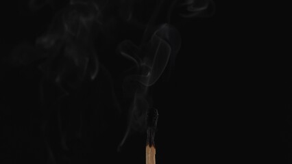 Macro shot of a black charred match and clouds of white smoke. Burned extinguished wooden match on...