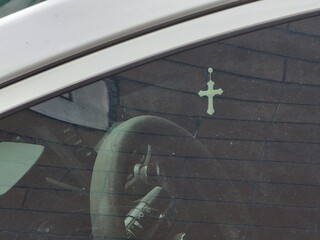Crucifix on the rearview mirror of a car