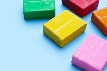 Colorful plasticine clay on blue background.
