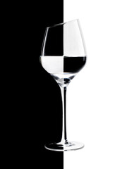 Stylish wine glass with a beveled edge on a black and white background. Refraction effect
