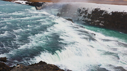 Beautiful water stream iceland nature with snowy fields and mountains, gullfoss waterfall in...