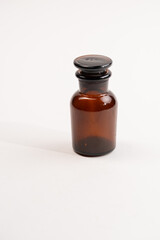 bottle with a medicine,Brown glass chemical bottle with the ground stopper on the white...