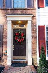 Close-up view of the front door in a brick house. Christmas decoration. facade design.
