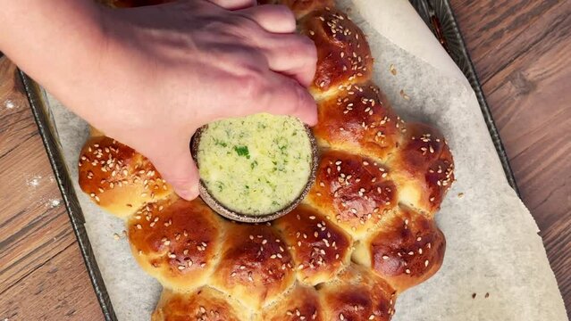 Freshly baked yeast dough bread buns and melted butter with chopped garlic and parsley, top view