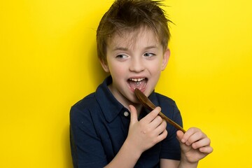 a boy of Slavic appearance holds a reusable bamboo spoon in his hands