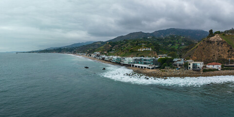 Malibu beach aerial view in California near Los Angeles, USA. Waves hitting the shore near expensive houses in Malibu.