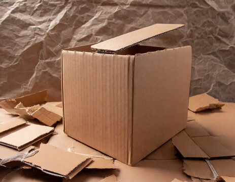 Cardboard box on torn paper background texture. Recycling concept and brown cardboard pieces